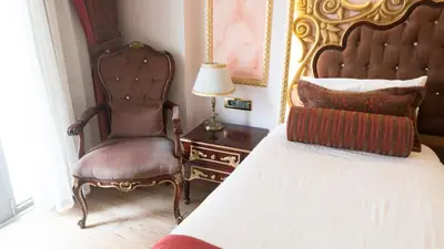 a bedroom with a bed and a chair and a lamp at Golden Marmara Hotel in Istanbul