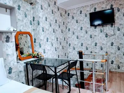 a dining room with a table and chairs and a tv on a wall at Ease Inn in Istanbul