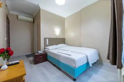 a bedroom with a bed and a desk and a bed sidx sidx sidx at OTEL ÜMIT İSTANBUL in Istanbul