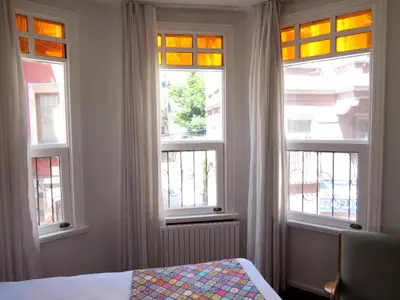 a bedroom with three windows and a bed in it at Istanberry - Luna Apartments in Istanbul