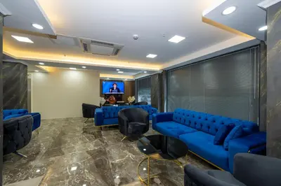 a waiting room with blue couches and a tv at SKYSTAR DELUXE HOTEL in Istanbul