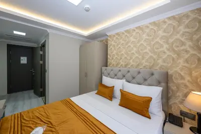 a bedroom with a large bed with orange pillows at SKYSTAR DELUXE HOTEL in Istanbul
