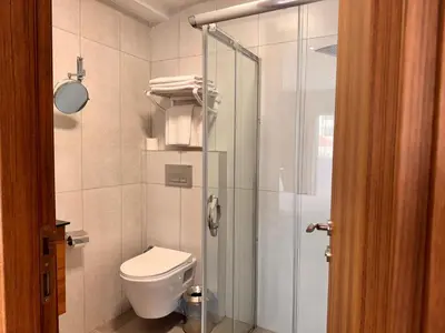 a bathroom with a toilet and a glass shower at İNNPORT HOTEL in Gebze